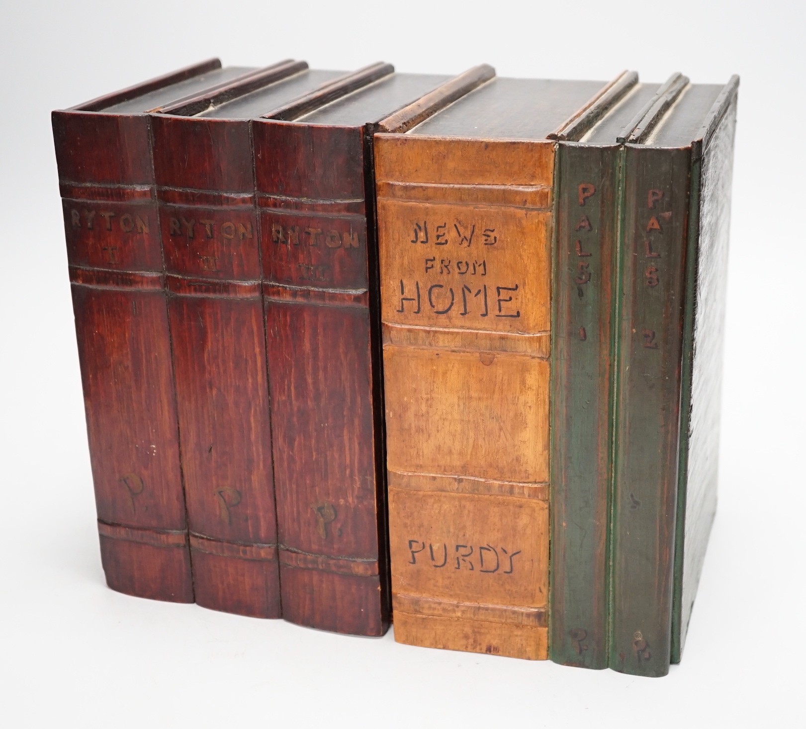 An early 20th century painted carved oak novelty stationary box modelled as books, 27cm wide, 23cm tall, 16cm deep